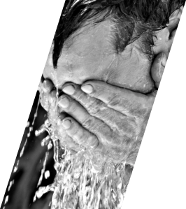 Mann, der sich mit den Händen Wasser das Gesicht wäscht